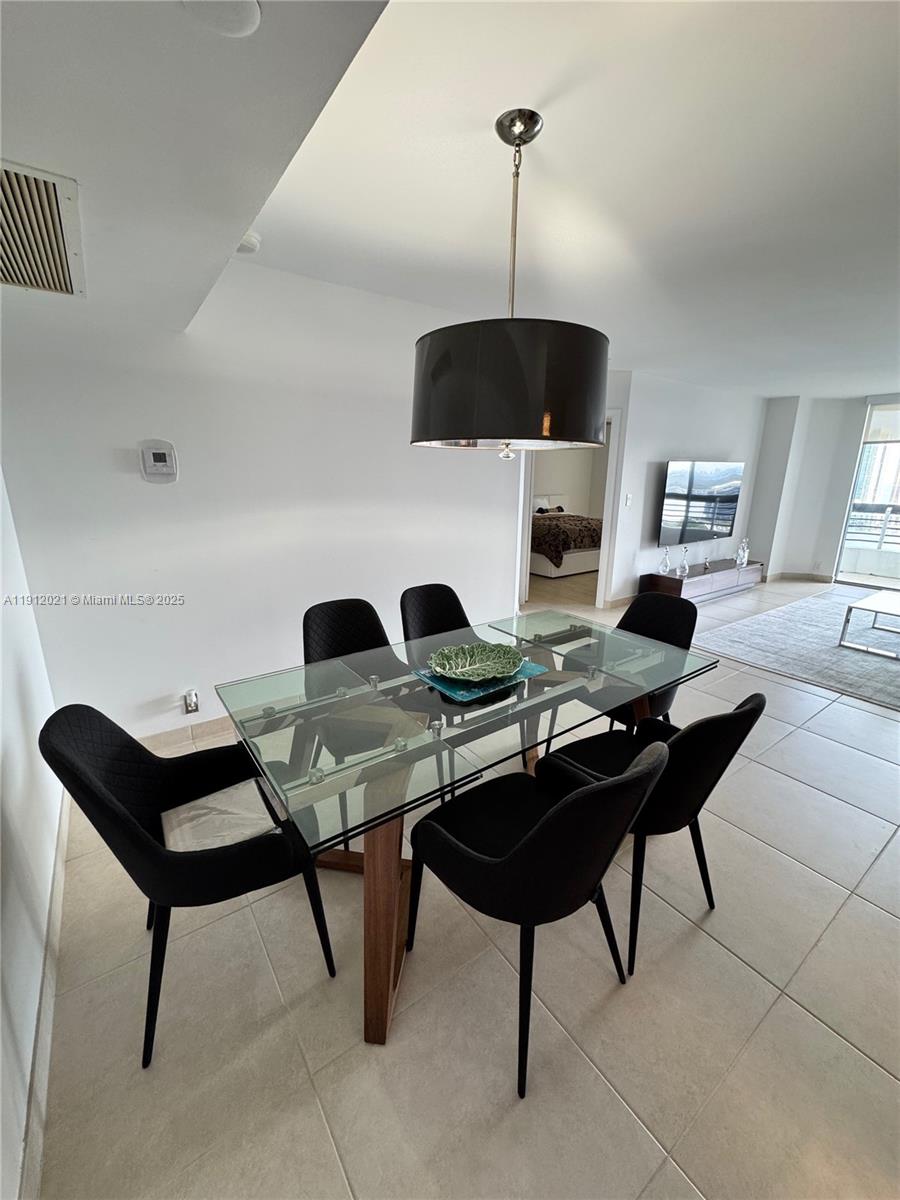 3530 Mystic Pointe Drive, Unit 3111 Aventura, FL 33180 - Photo 11 of 22 a living room with furniture and a flat screen tv