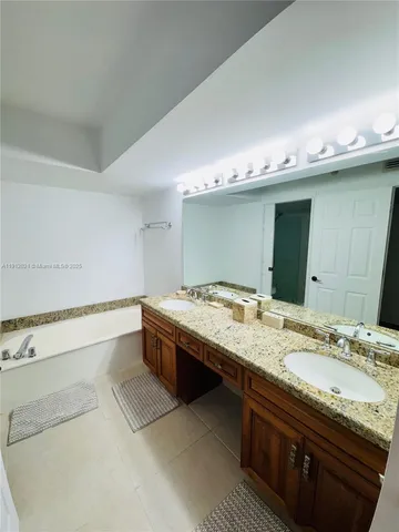 a spacious bathroom with a granite countertop sink and a mirror