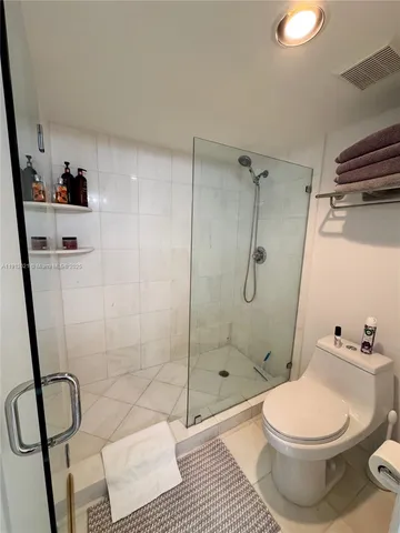 a bathroom with a toilet and a shower