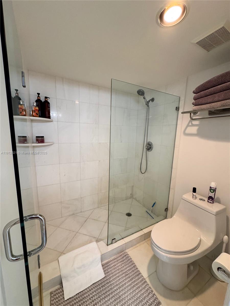 3530 Mystic Pointe Drive, Unit 3111 Aventura, FL 33180 - Photo 15 of 22 a bathroom with a toilet and a shower