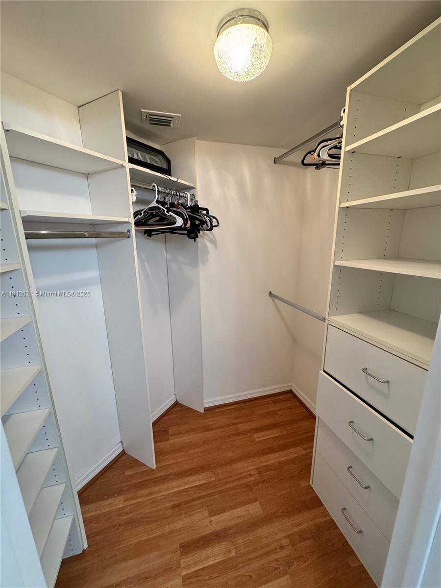 3530 Mystic Pointe Drive, Unit 3111 Aventura, FL 33180 - Photo 16 of 22 a view of walk in closet with empty racks