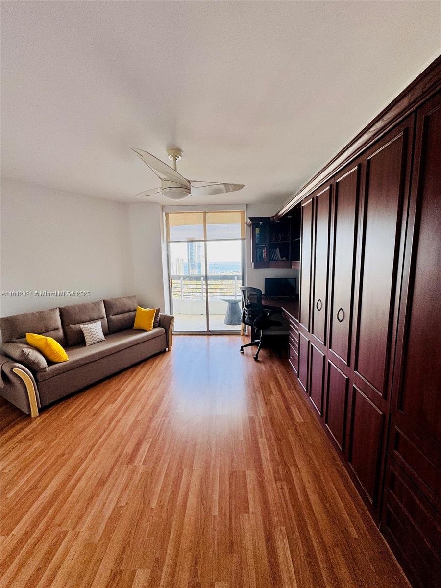 3530 Mystic Pointe Drive, Unit 3111 Aventura, FL 33180 - Photo 17 of 22 a living room with furniture and a wooden floor