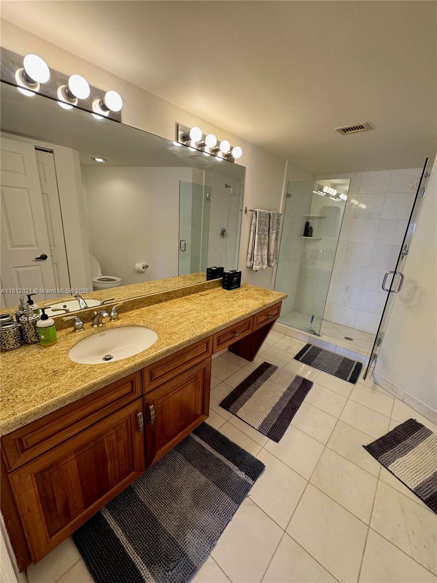 3530 Mystic Pointe Drive, Unit 3111 Aventura, FL 33180 - Photo 20 of 22 a bathroom with a sink double vanity granite and a mirror