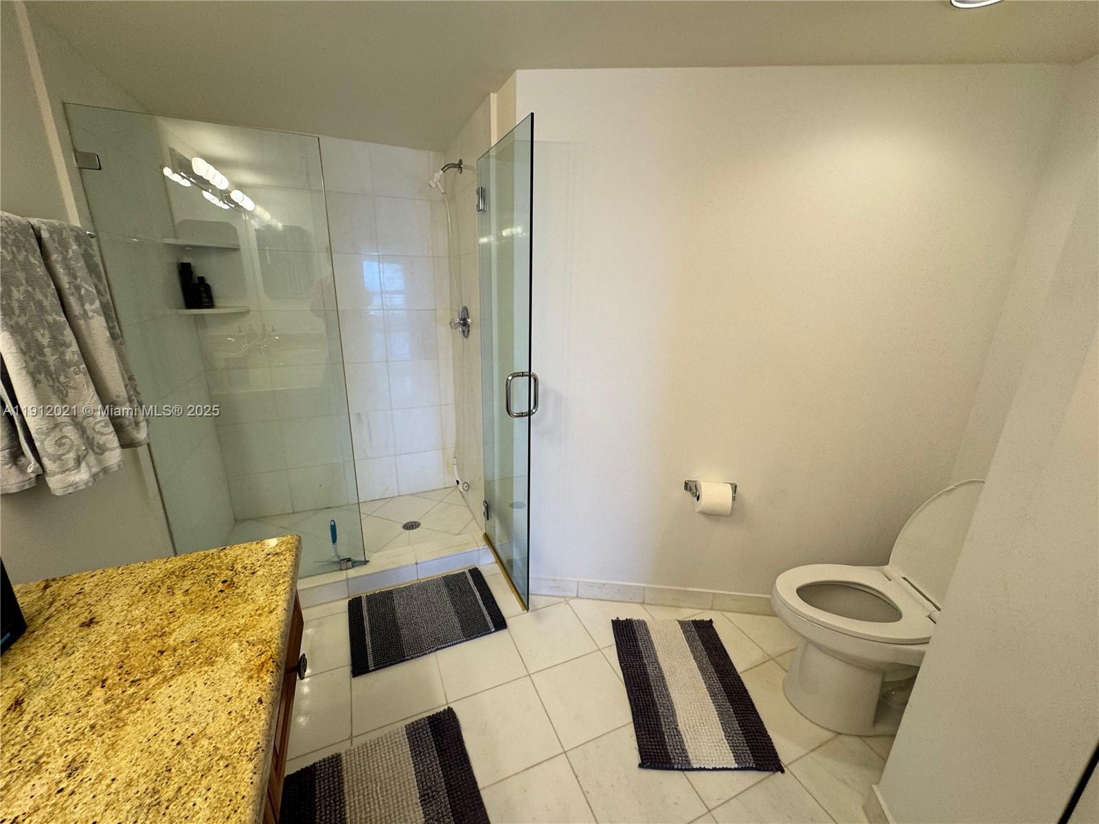 3530 Mystic Pointe Drive, Unit 3111 Aventura, FL 33180 - Photo 21 of 22 a bathroom with a sink a toilet and shower