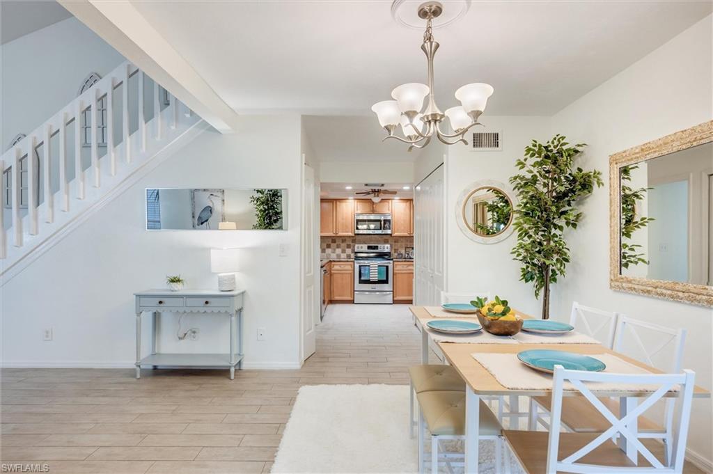 940 Augusta Boulevard, Unit D939 Naples, FL 34113 - Photo 13 of 42 a view of a dining room with furniture and a chandelier
