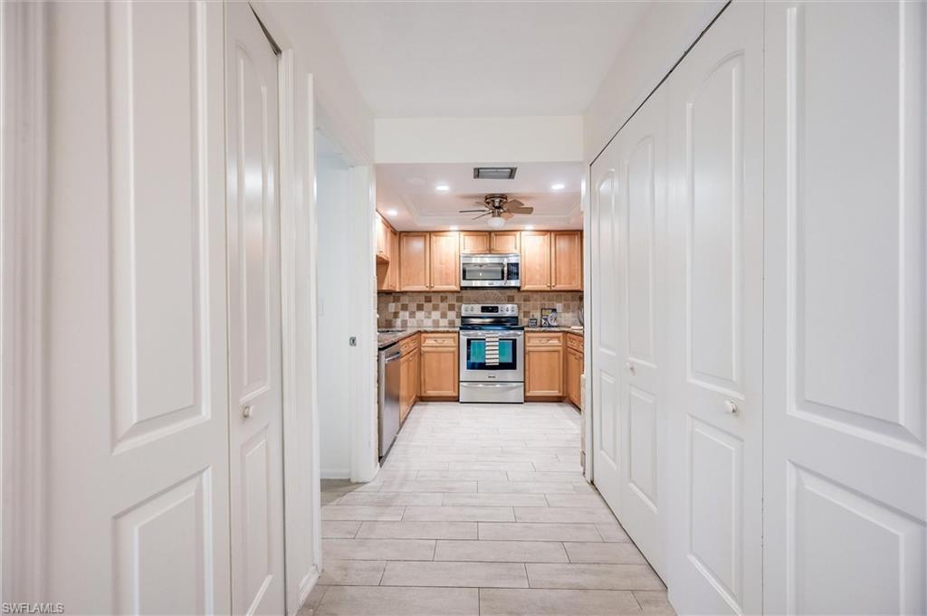 940 Augusta Boulevard, Unit D939 Naples, FL 34113 - Photo 14 of 42 a kitchen with stainless steel appliances granite countertop a refrigerator and a sink