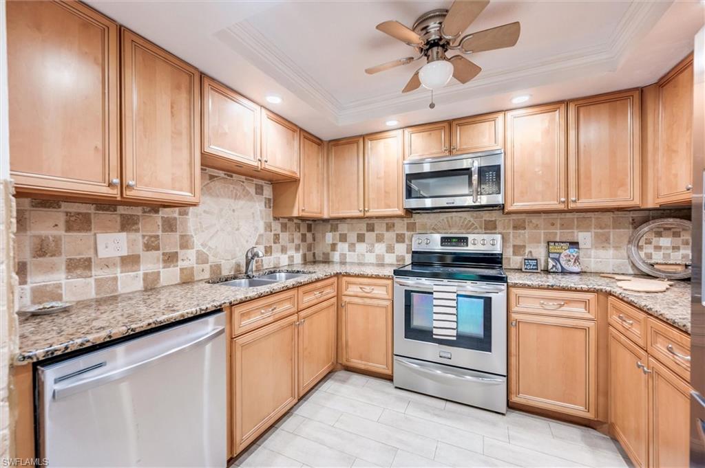 940 Augusta Boulevard, Unit D939 Naples, FL 34113 - Photo 15 of 42 a kitchen with granite countertop cabinets stainless steel appliances a sink and a counter top space