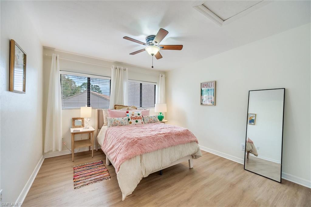 940 Augusta Boulevard, Unit D939 Naples, FL 34113 - Photo 22 of 42 a bedroom with a bed and a chandelier