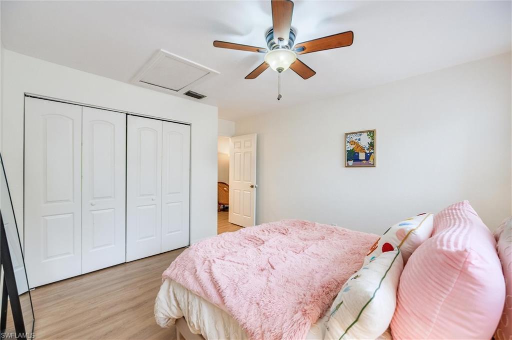 940 Augusta Boulevard, Unit D939 Naples, FL 34113 - Photo 24 of 42 a bedroom with a bed and a chandelier
