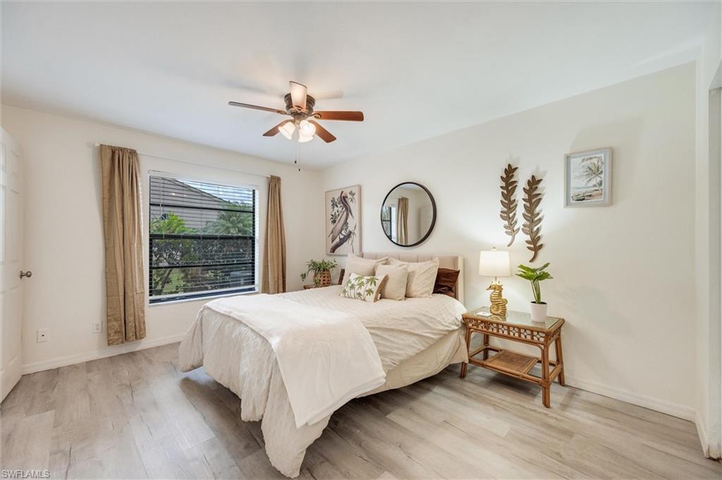 940 Augusta Boulevard, Unit D939 Naples, FL 34113 - Photo 27 of 42 a bedroom with a bed wooden floor and window
