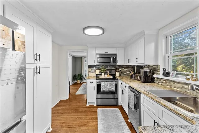 a bedroom with a bed and a dresser with wooden floor