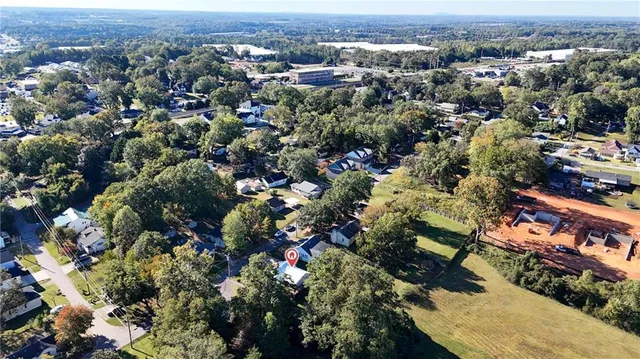 an aerial view of a houses with a lush green hillside