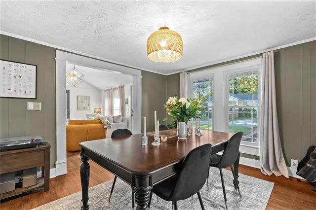 a kitchen with granite countertop a refrigerator a stove a sink and white cabinets with wooden floor