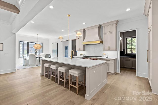 a large kitchen with kitchen island a sink a stove a dining table and chairs