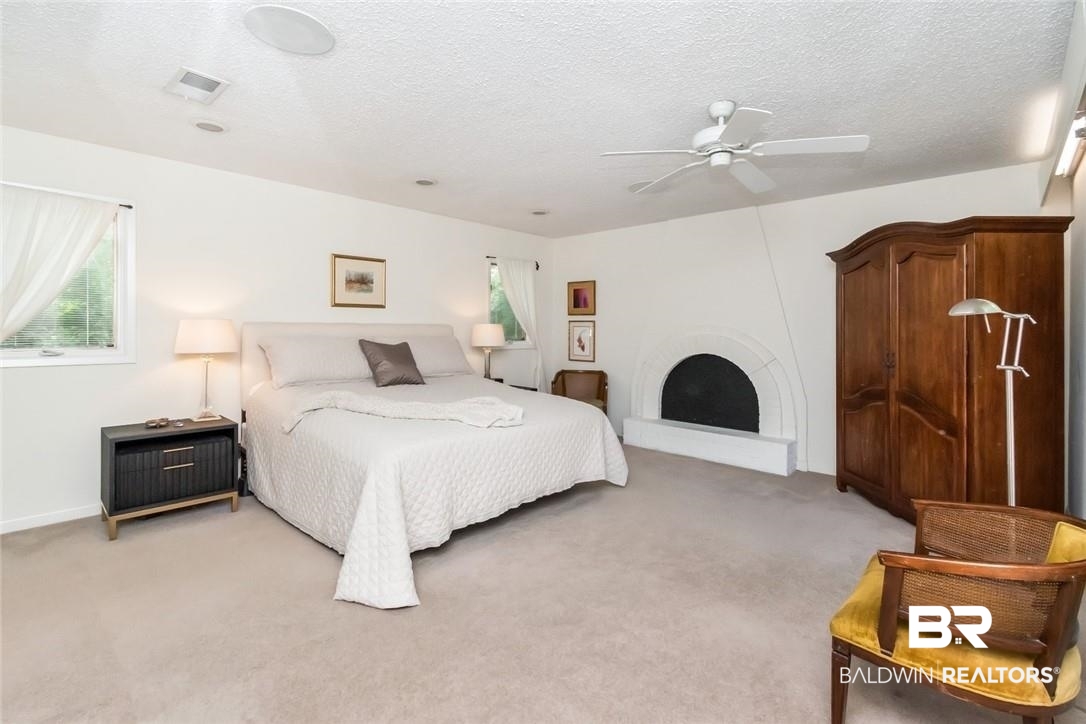 305 Fern Hill Court Mobile, AL 36608 - Photo 23 of 53 Bedroom featuring ceiling fan, a textured ceiling, a fireplace, and light carpet