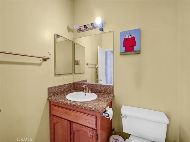 a bathroom with a toilet a sink and mirror
