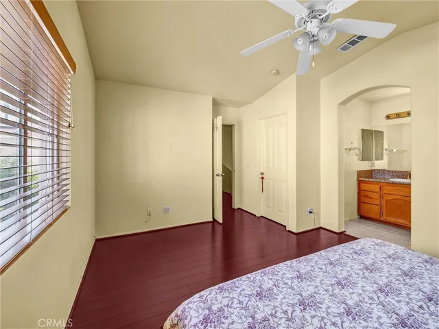 a view of a room with wooden floor and a ceiling fan