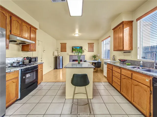 a large kitchen with stainless steel appliances granite countertop a stove a sink dishwasher and a refrigerator
