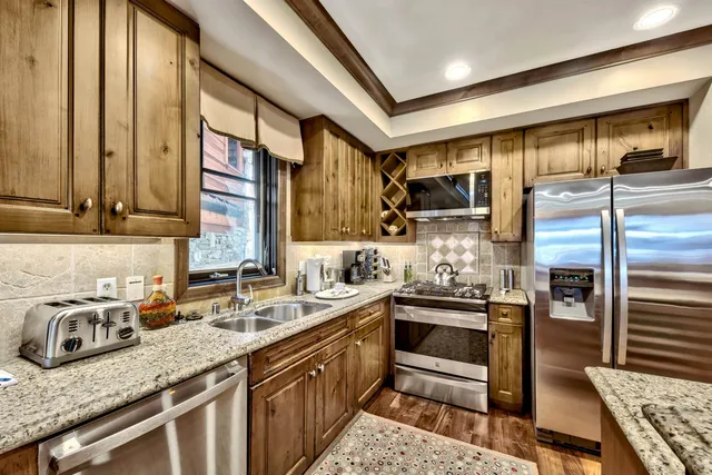 a kitchen with stainless steel appliances granite countertop a sink stove and cabinets