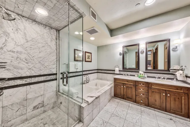a spacious bathroom with a granite countertop sink mirror and bathtub