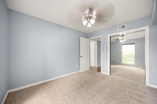 a front view of a building with cars parked