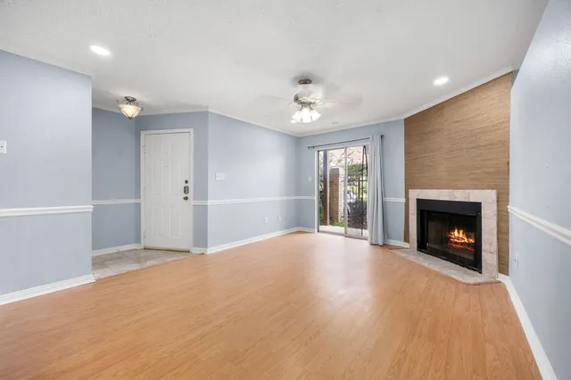 a view of an empty room with a fireplace and a window