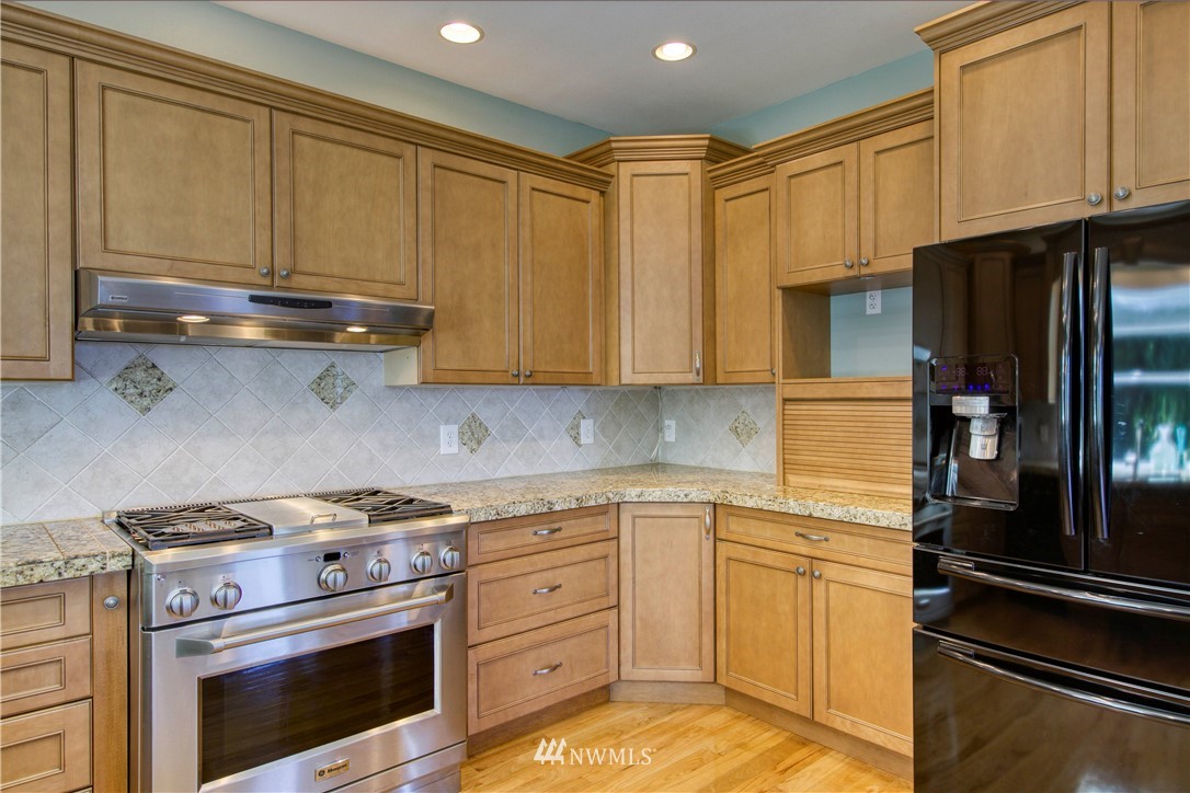 20821 Miller Bay Road Northeast Poulsbo, WA 98370 - Photo 11 of 40 a kitchen with granite countertop cabinets stainless steel appliances and a counter space