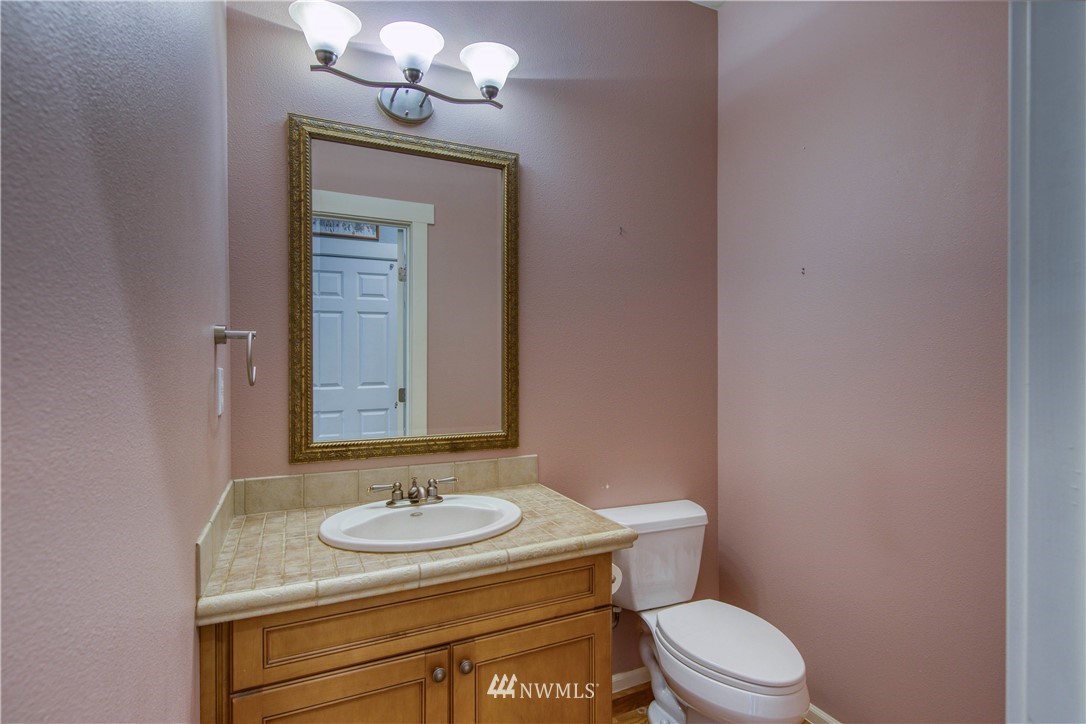 20821 Miller Bay Road Northeast Poulsbo, WA 98370 - Photo 16 of 40 a bathroom with a granite countertop sink a toilet and mirror