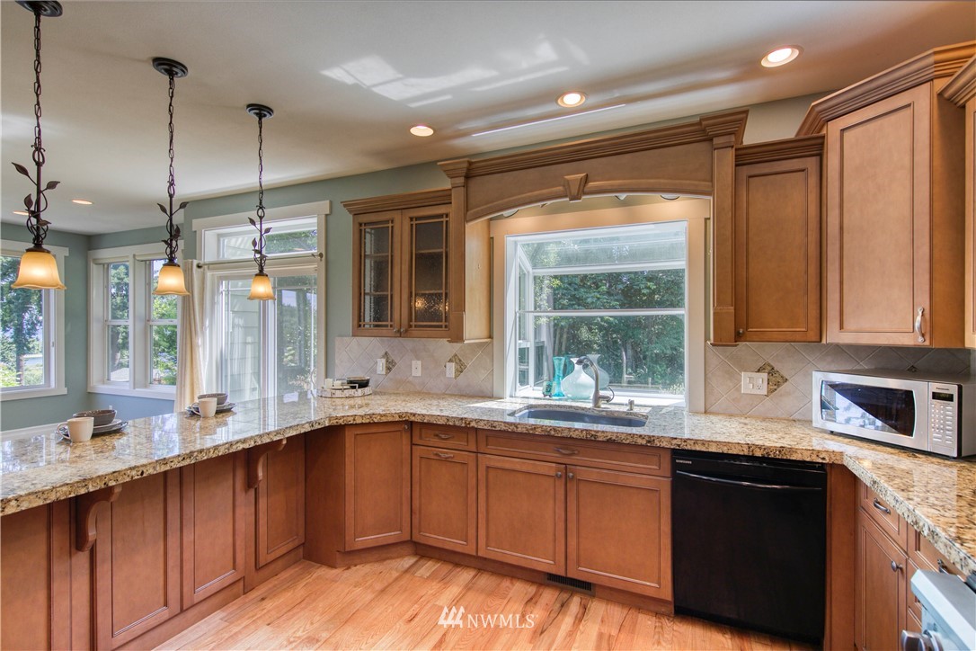 20821 Miller Bay Road Northeast Poulsbo, WA 98370 - Photo 10 of 40 a kitchen with a sink window and cabinets