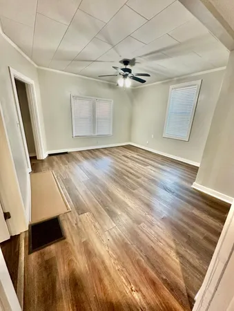 a view of empty room with wooden floor