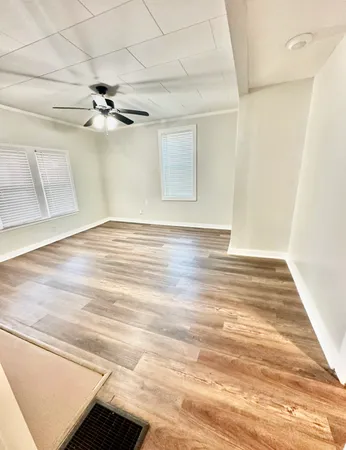 a view of an empty room with wooden floor