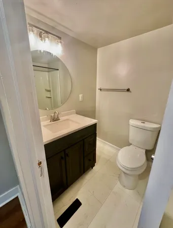 a bathroom with a sink vanity mirror and toilet
