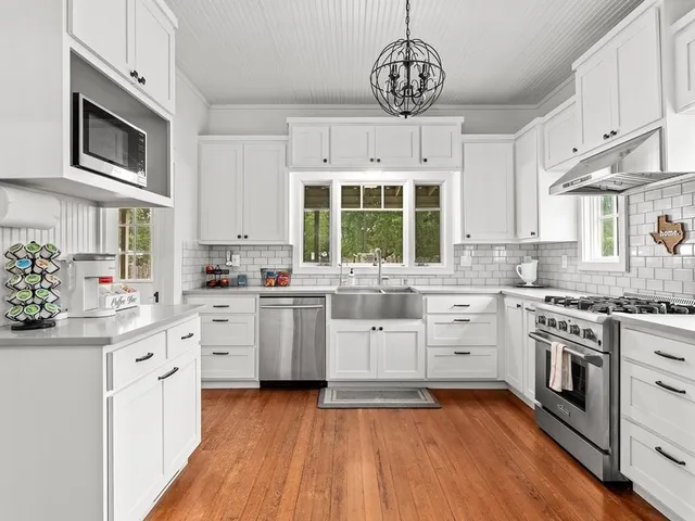 a kitchen with stainless steel appliances granite countertop a stove and cabinets