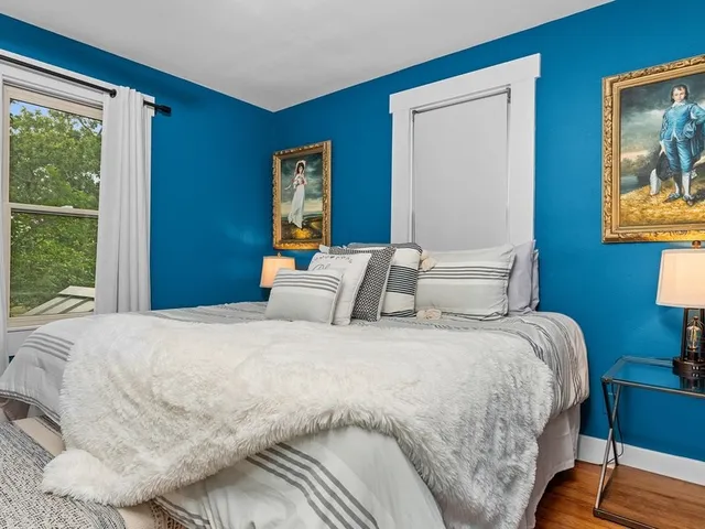 a bedroom with bed and wooden floor