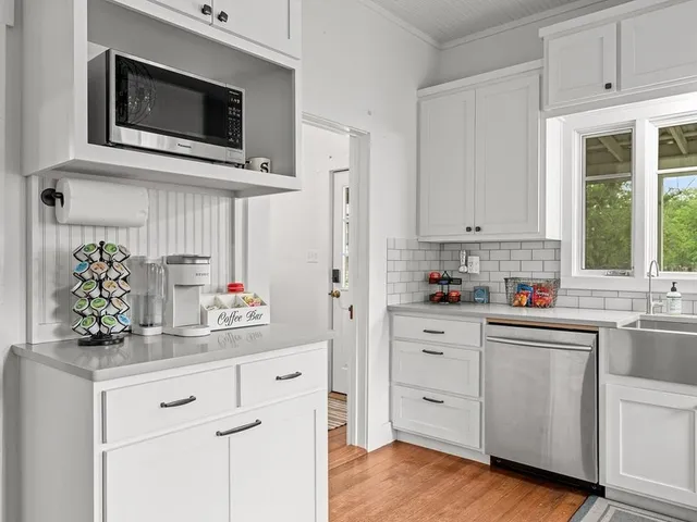 a kitchen with white cabinets and white appliances