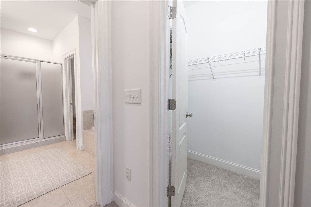 7 Divots Landing Salem, SC 29676 - Photo 22 of 47 This interior image showcases a primary bathroom with a walk-in closet, offering ample storage and bathing facilities.