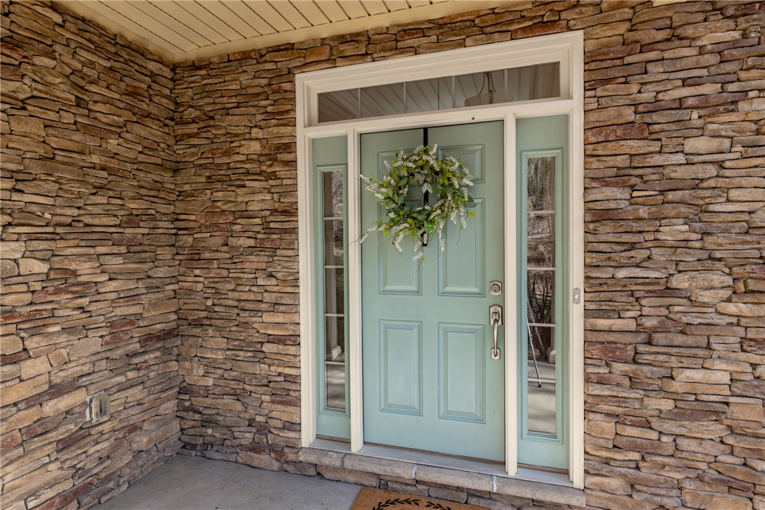 7 Divots Landing Salem, SC 29676 - Photo 4 of 47 The inviting entrance features a prominent door with elegant side windows, framed by rustic stone.