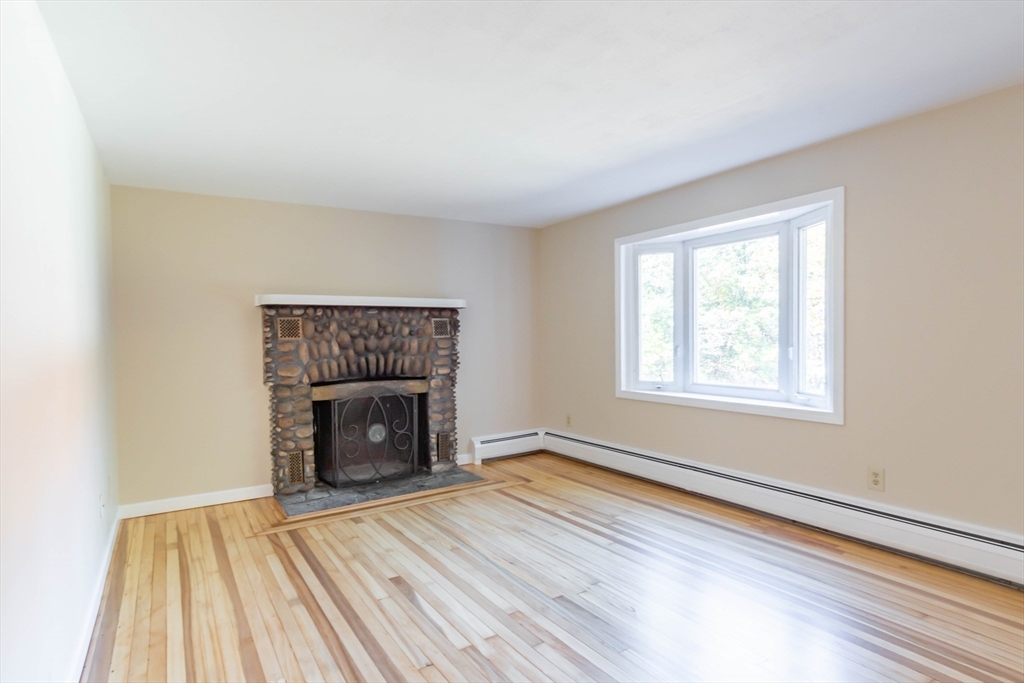 137 Lowell Road Pepperell, MA 01463 - Photo 11 of 40 an empty room with fireplace and windows
