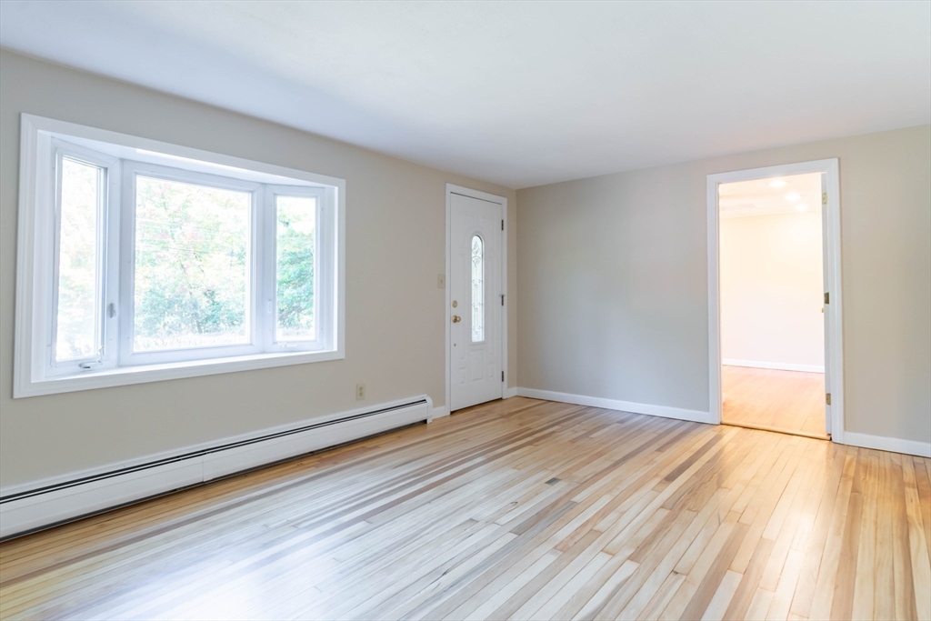 137 Lowell Road Pepperell, MA 01463 - Photo 12 of 40 a view of an empty room with wooden floor and a window