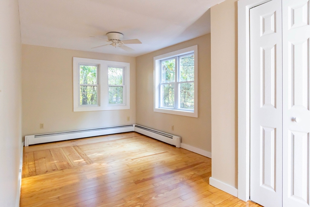 137 Lowell Road Pepperell, MA 01463 - Photo 19 of 40 a view of an empty room with wooden floor and a window
