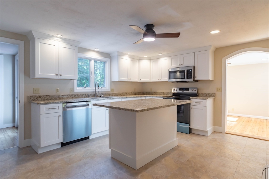 137 Lowell Road Pepperell, MA 01463 - Photo 5 of 40 a kitchen with kitchen island granite countertop a stove cabinets and a refrigerator