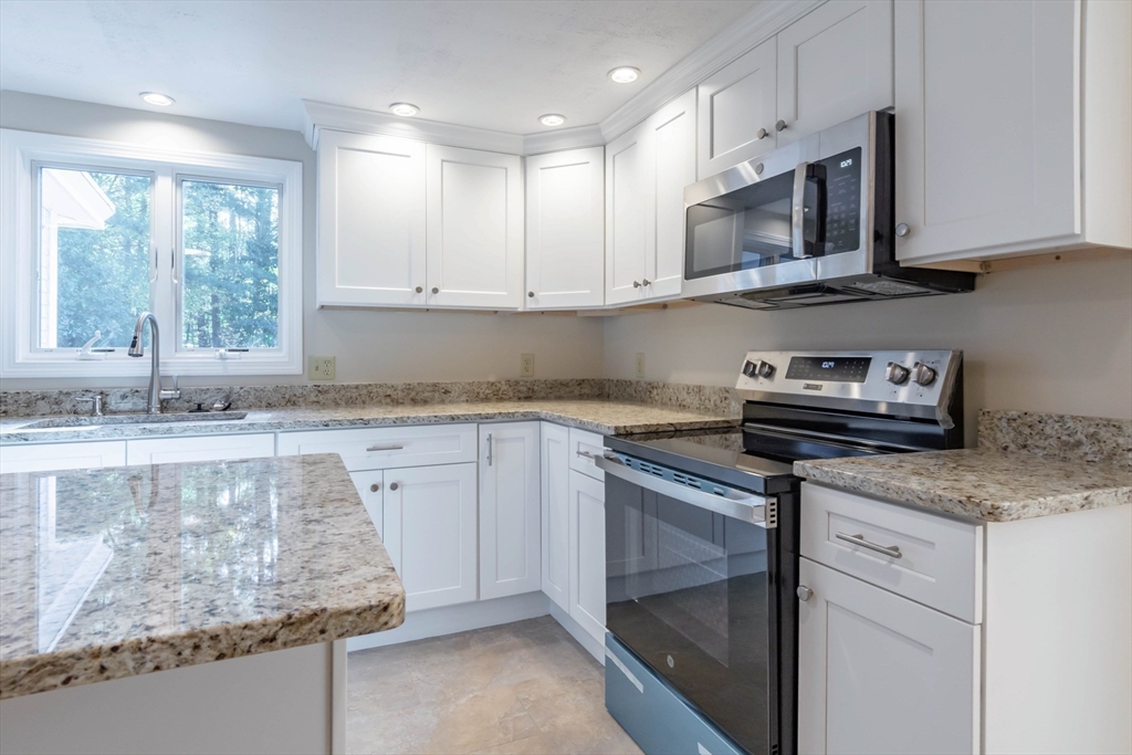 137 Lowell Road Pepperell, MA 01463 - Photo 8 of 40 a kitchen with stainless steel appliances granite countertop a sink stove and microwave