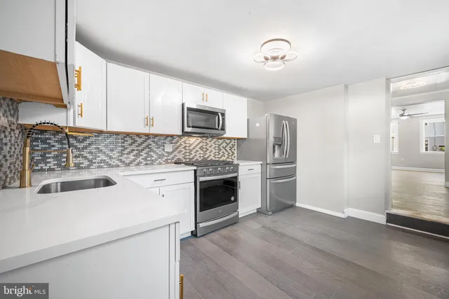 a kitchen with sink a microwave and cabinets
