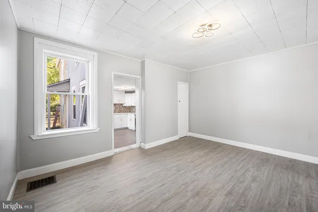a view of an empty room with wooden floor