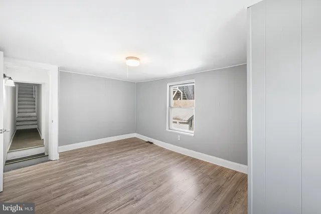 a view of an empty room with wooden floor