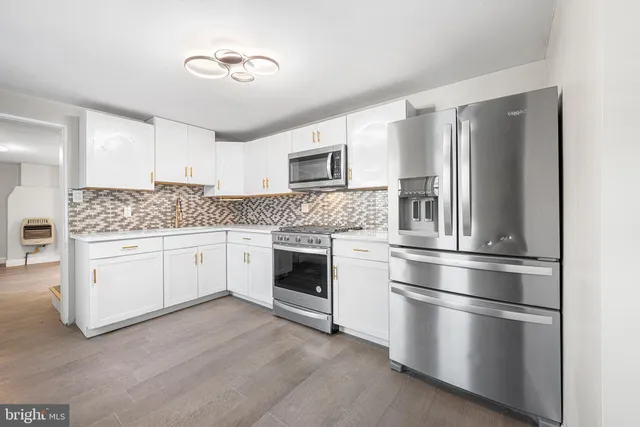 a kitchen with stainless steel appliances white cabinets and window