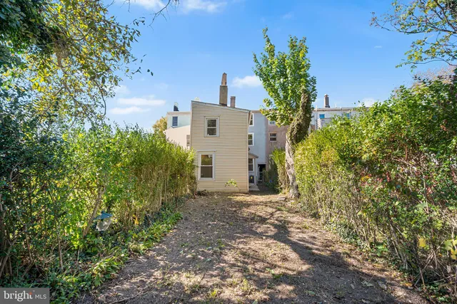 a view of a house with a yard and a tree