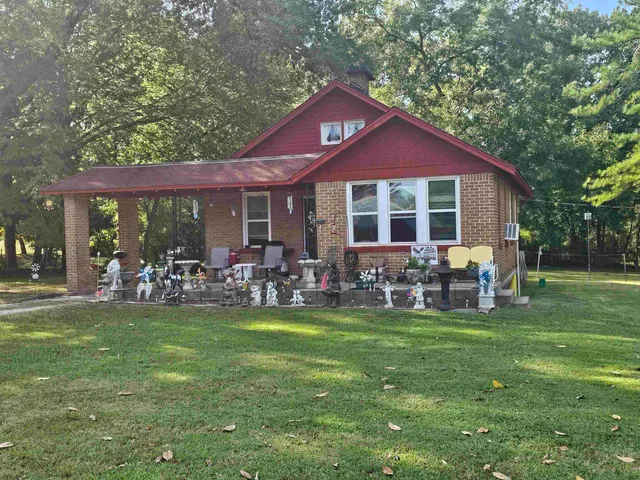 a view of a house with a yard and sitting area