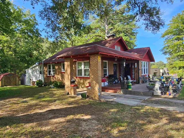 a front view of a house with porch and garden