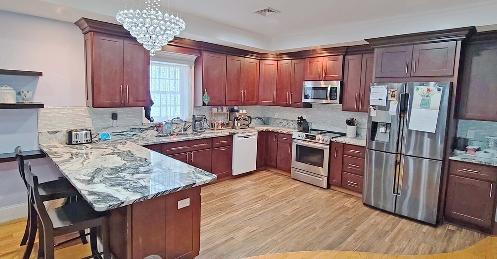 6 Sylvan Road Holbrook, MA 02343 - Photo 3 of 24 a kitchen with stainless steel appliances granite countertop a refrigerator a stove a sink dishwasher and microwave